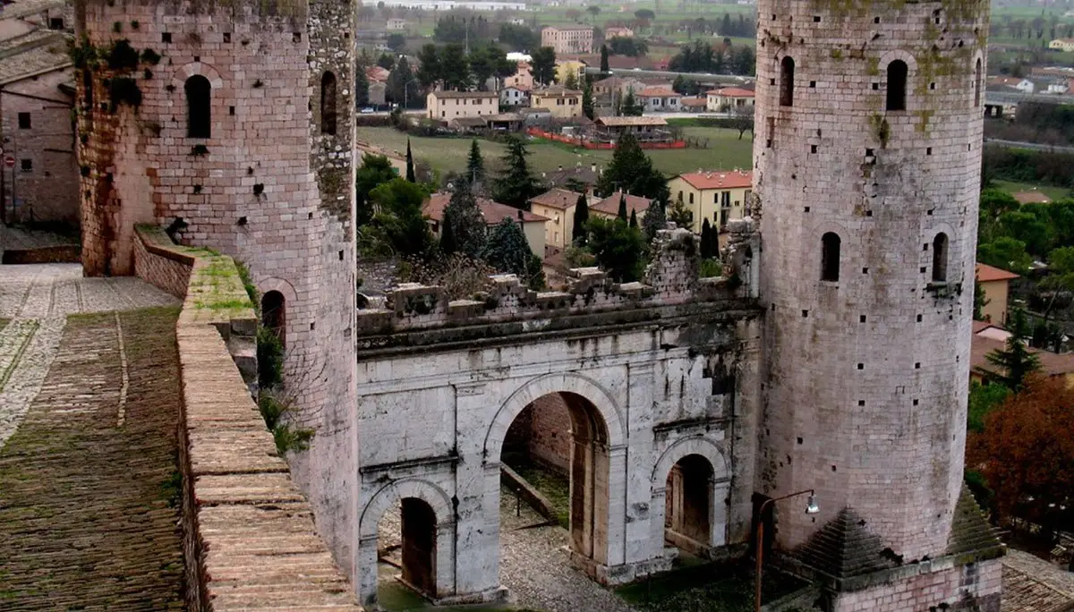 Un arco in pietra e le torri medievali di Bevagna
