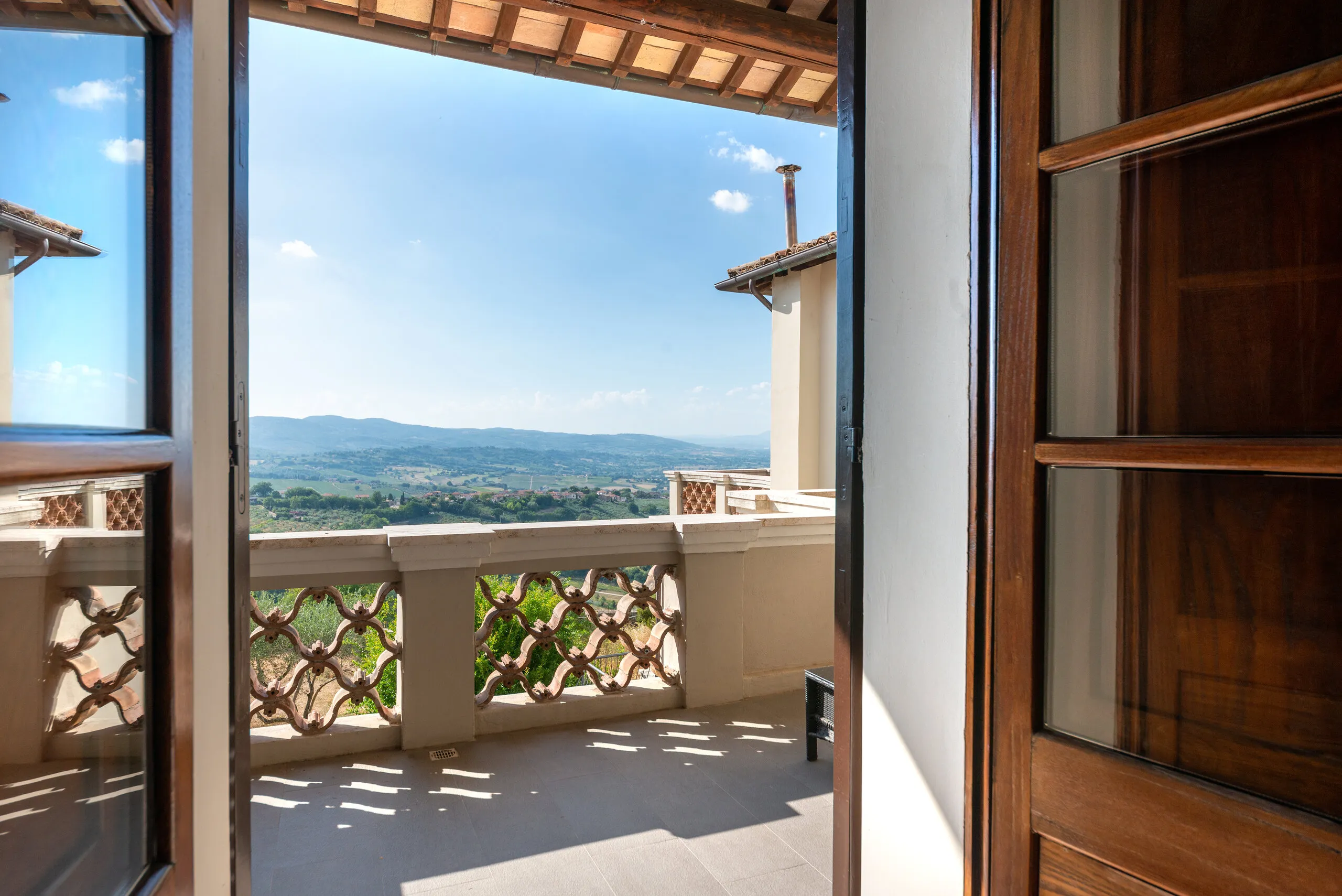 Le portefinestre della Deluxe aperte sul terrazzo e sulle colline