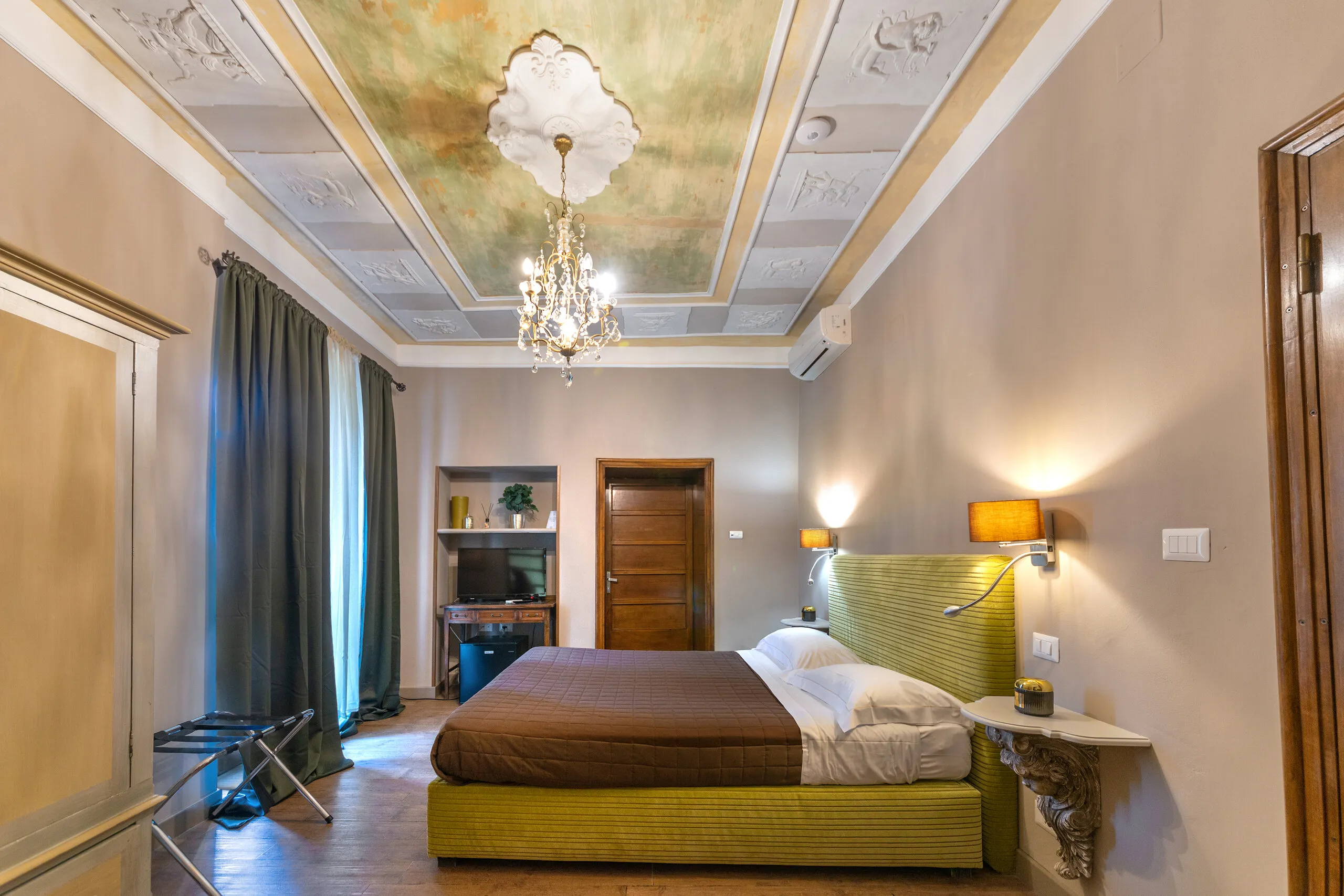 Il soffitto decorato della Family Superior, con rosone in gesso e lampadario di cristallo