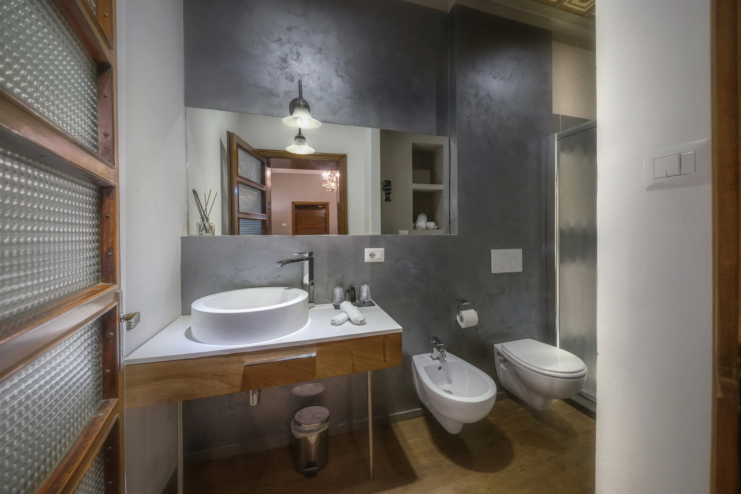 Il bagno della Family Superior, con pareti grigie e lavabo su piano in legno