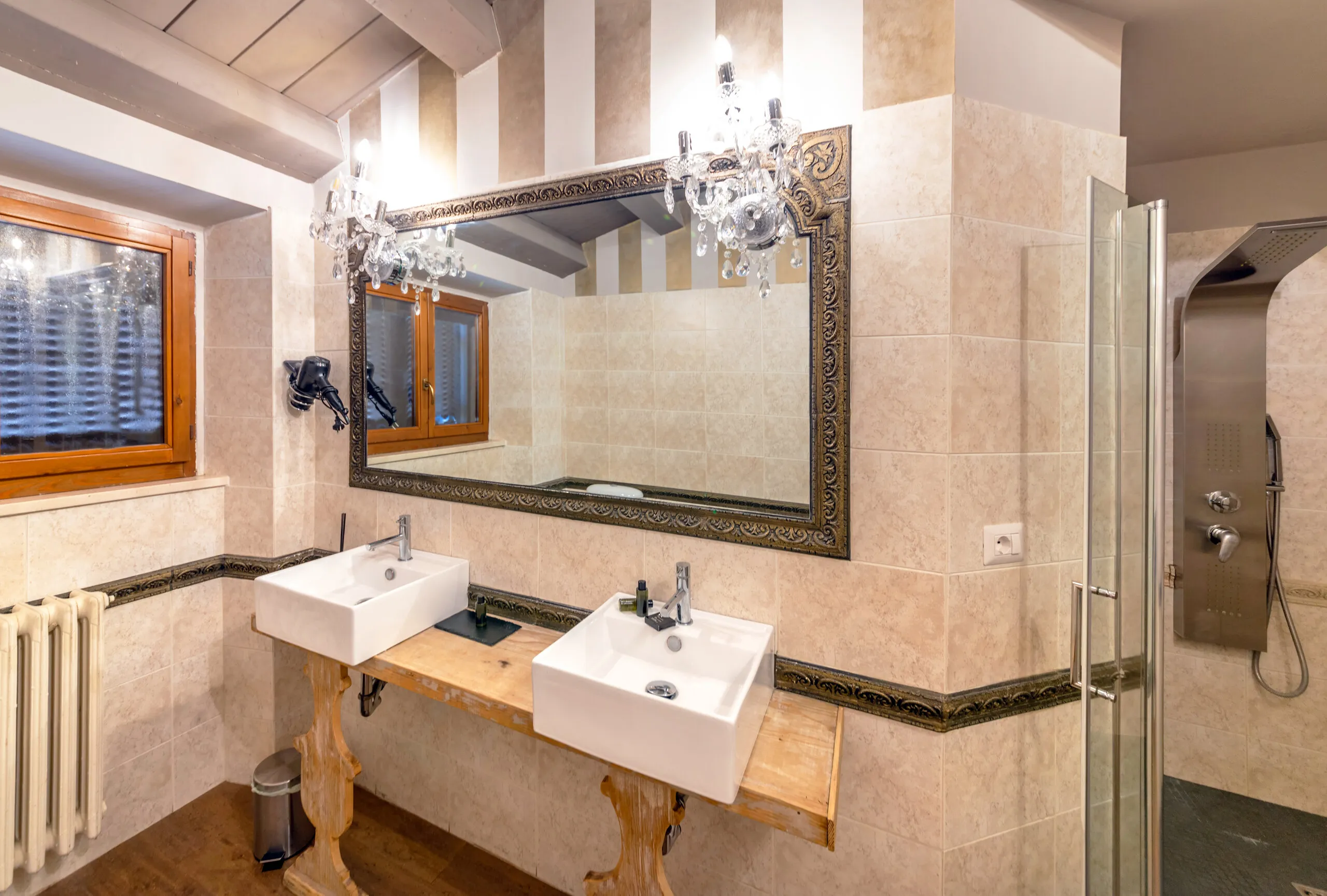 L’ampio bagno della Junior Suite, con doppio lavabo su consolle in legno