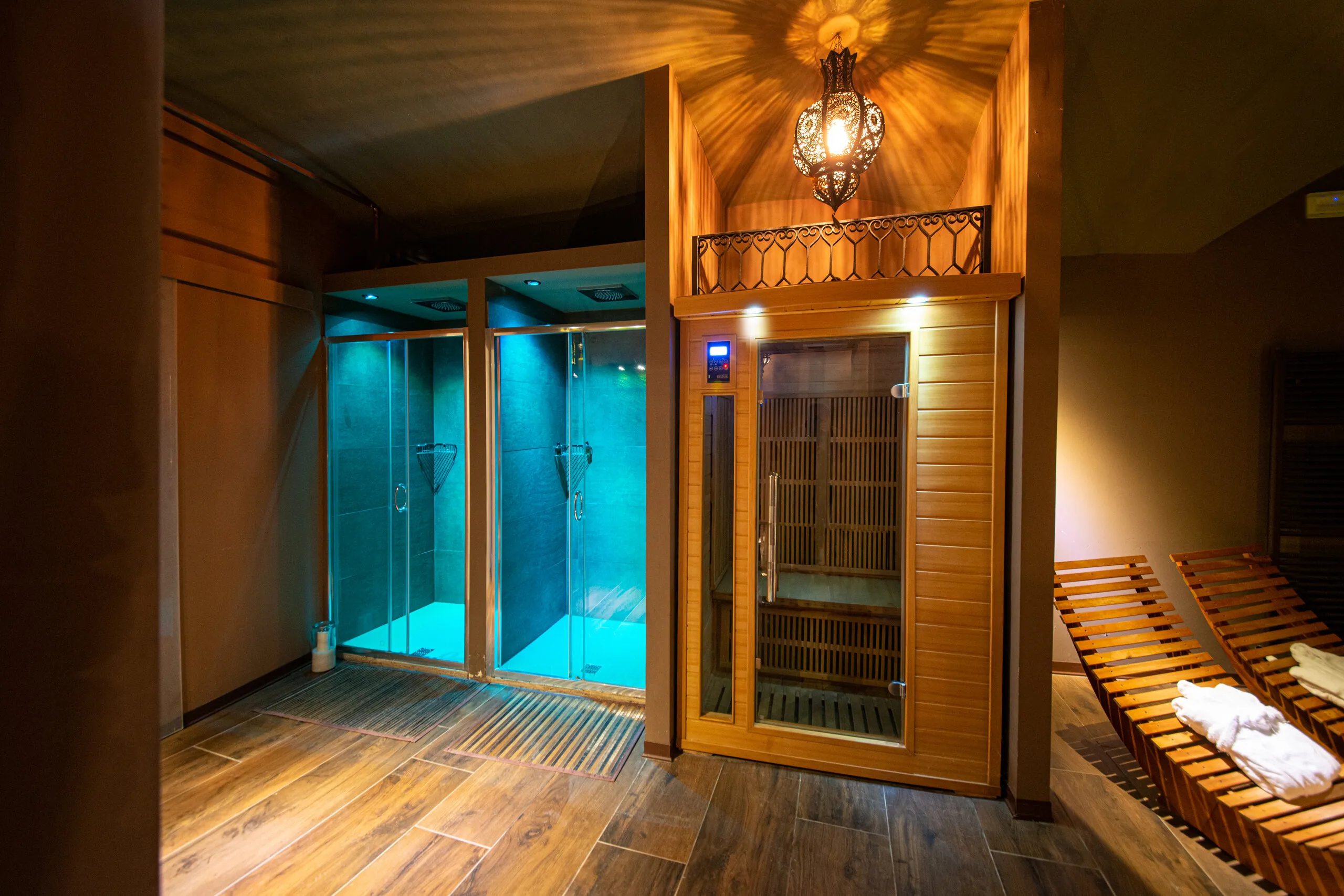 La cabina dell’hammam illuminata di turchese, accanto alla sauna a infrarossi