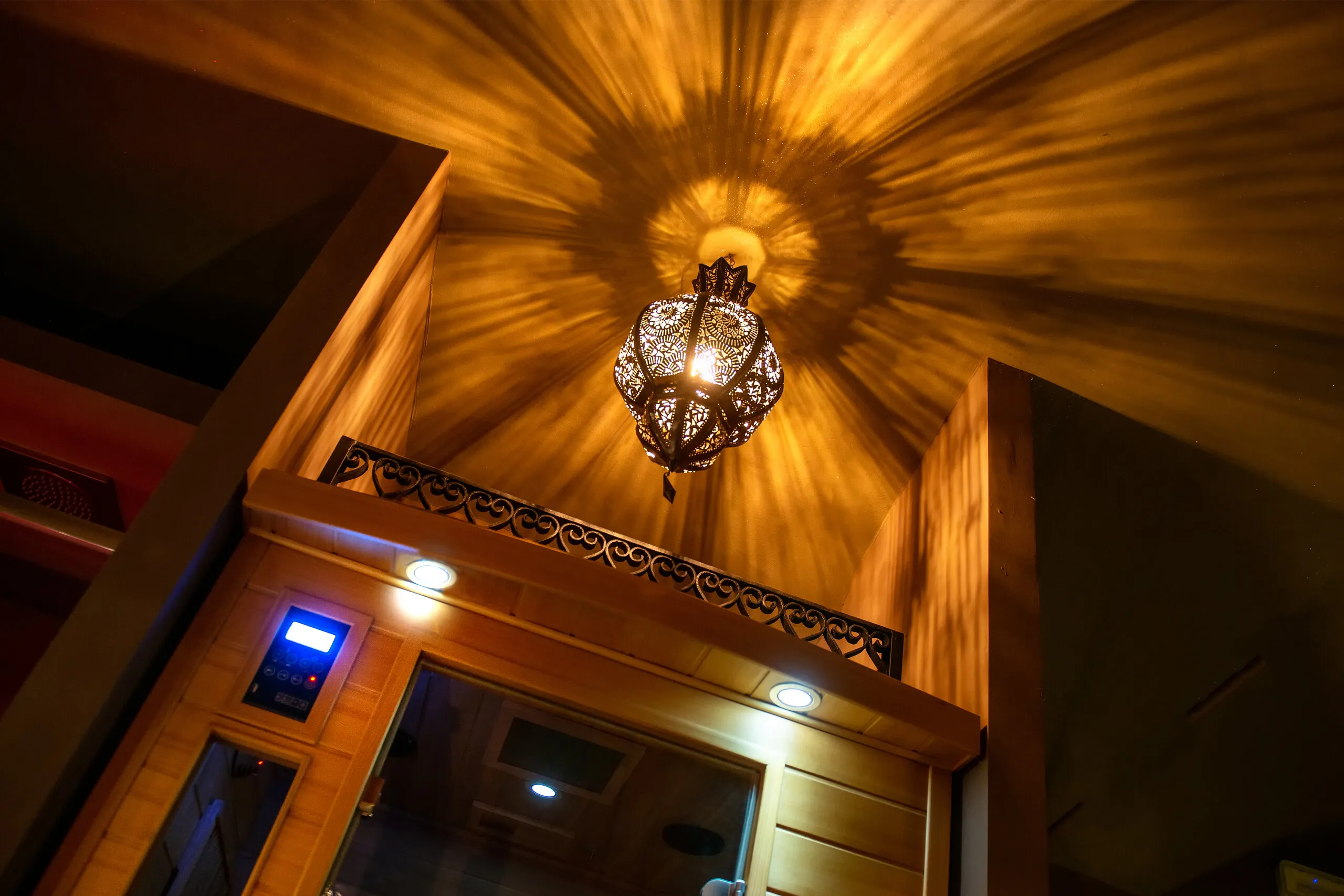 La cabina della sauna a infrarossi in legno chiaro, sotto la lanterna traforata