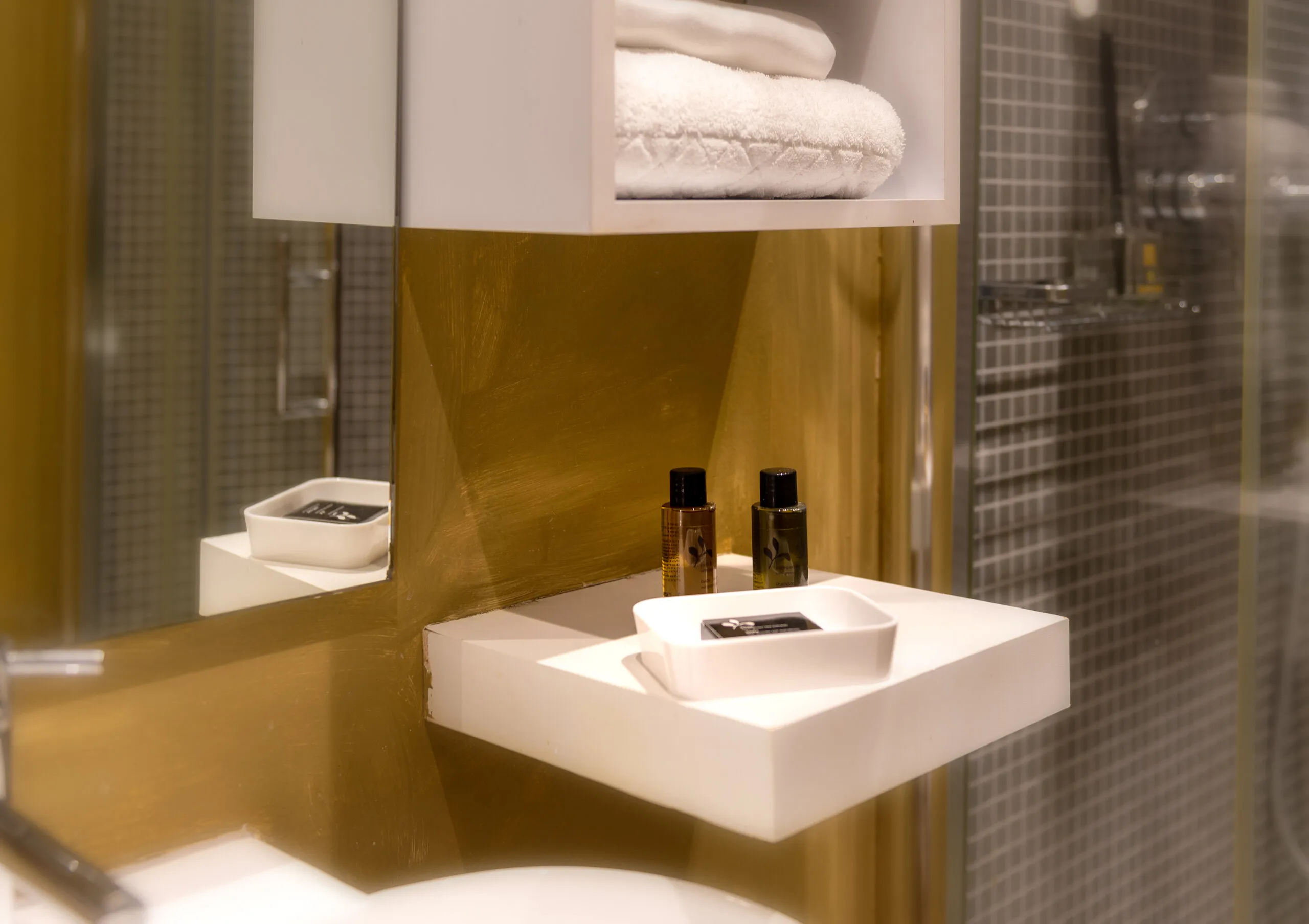 Cortesie da bagno e asciugamani della Standard 02 sulla mensola bianca